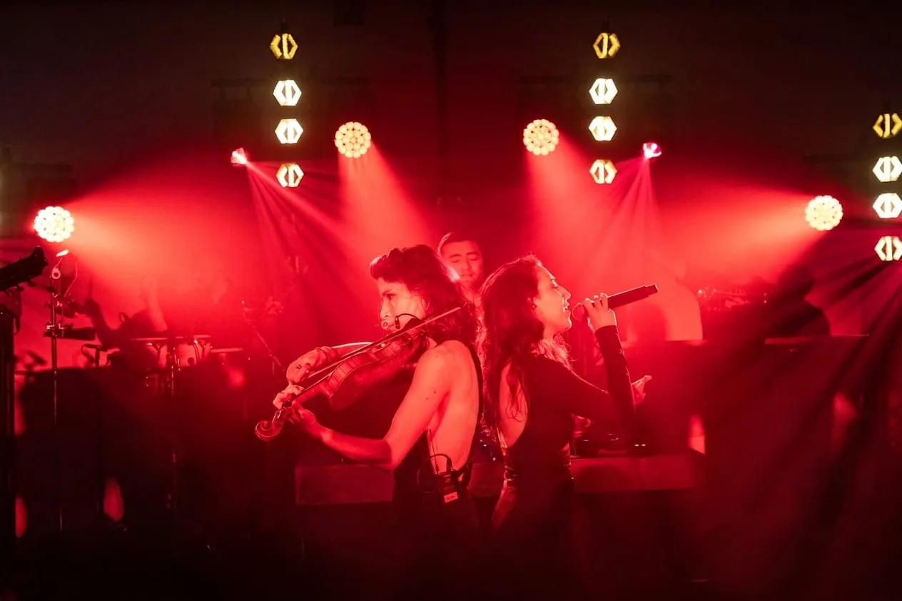 Violoniste et chanteuse dos à dos, lumière rouge de scène